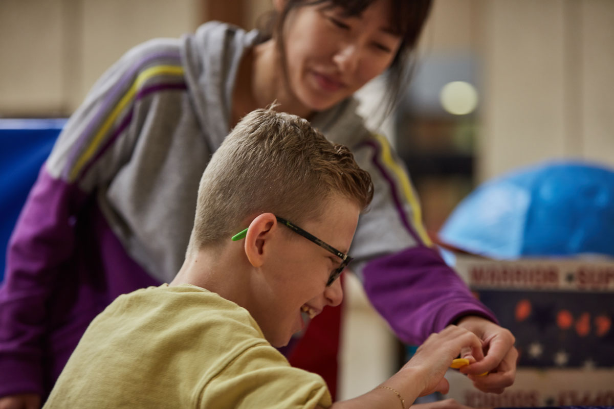 A graduate student works with a young client on bio-mechanics