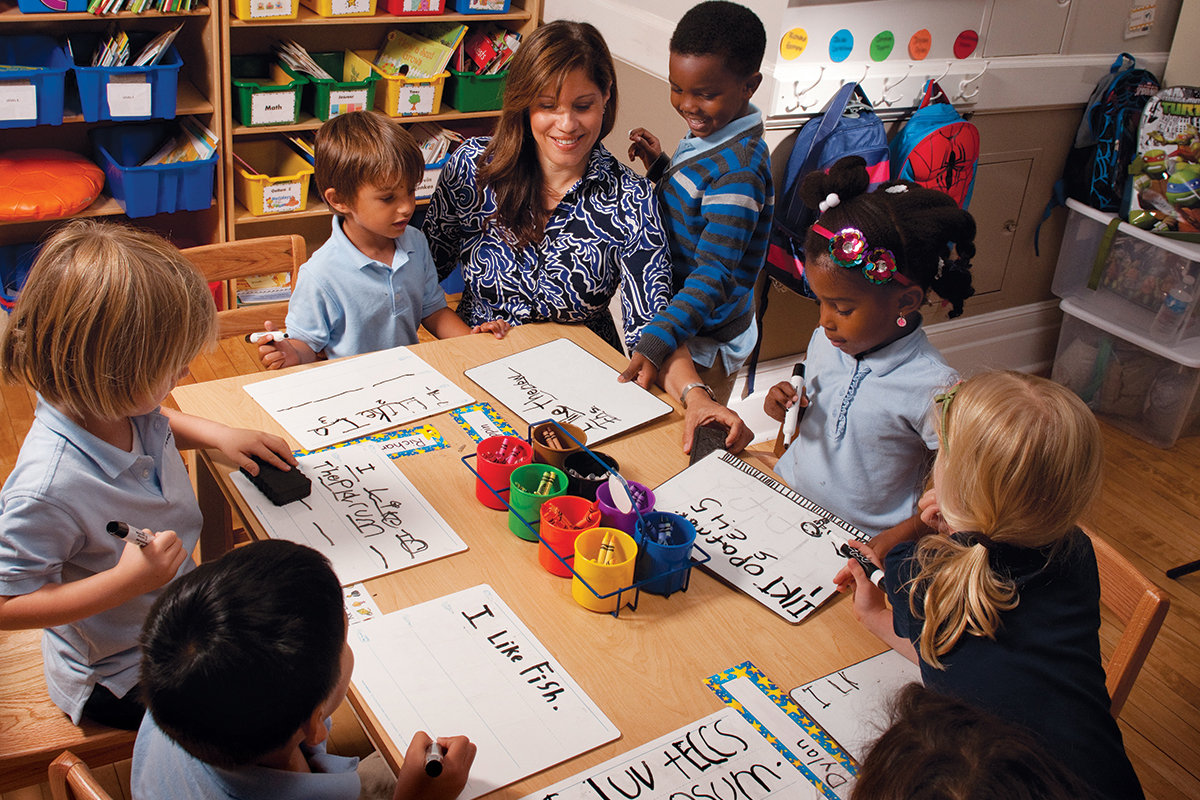 A teacher works with her students on writing exercises