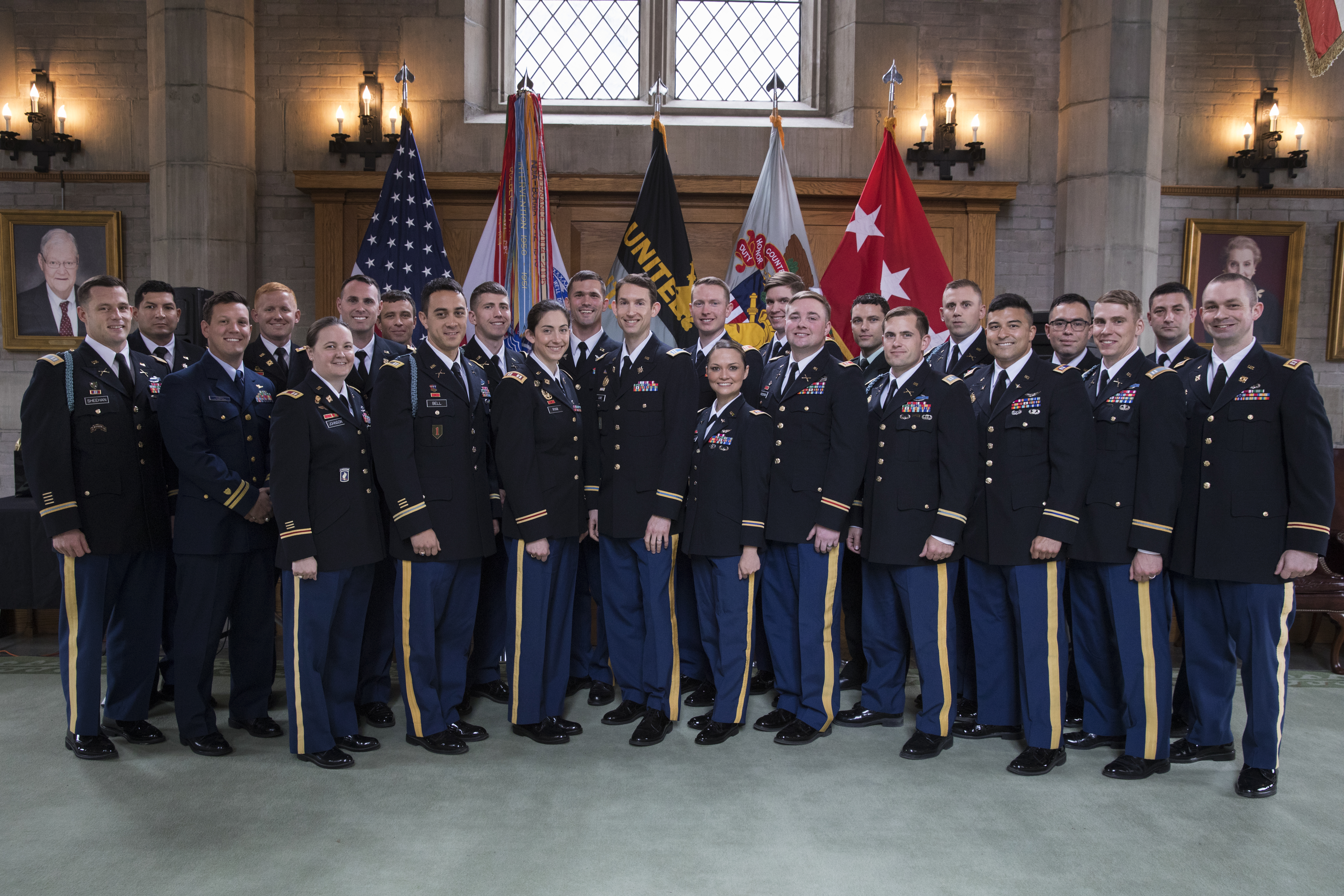ELDP cohort 14 in standing in uniform in front of flags.