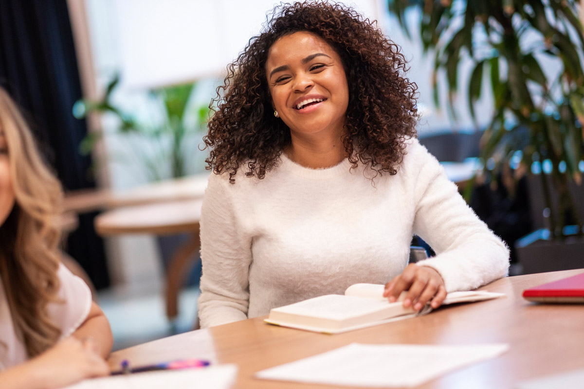 A graduate student smiles while she makes a point in a discussion with her peers at TC.