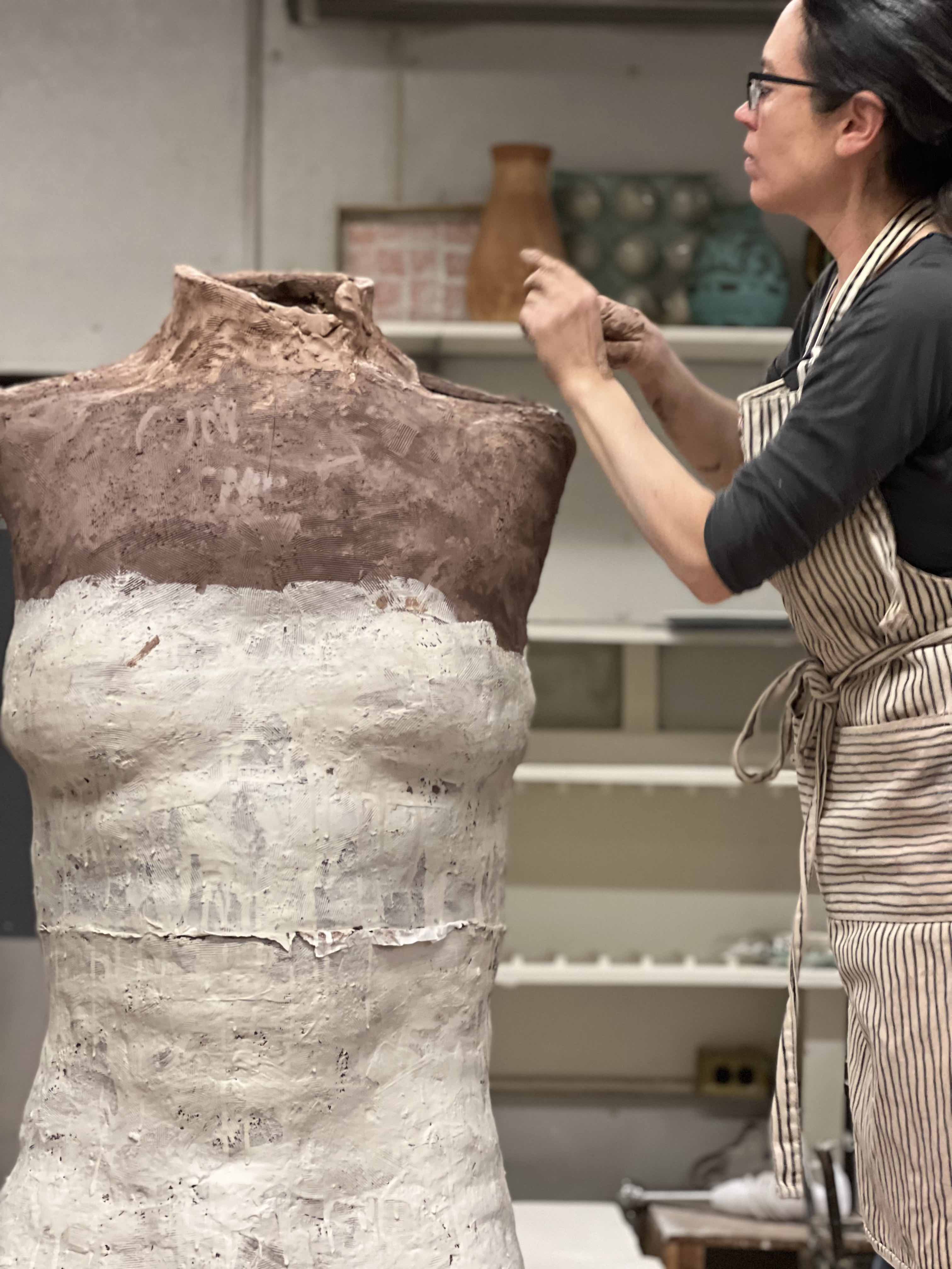 This picture depicts a women creating a sculpture.