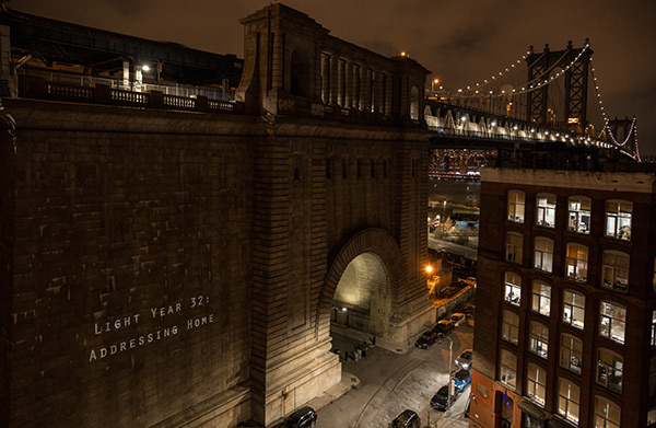 SPANNING DEEP WATERS “Addressing Home,” a series of TC student-created videos projected onto the anchorage of the Manhattan Bridge, aired in early December. (Photo Credit: Margaret Ferrec)