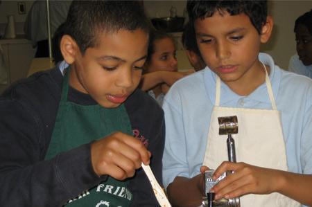 Two young students mix food as they learn about food choice via one of the Tisch Center's initiatives