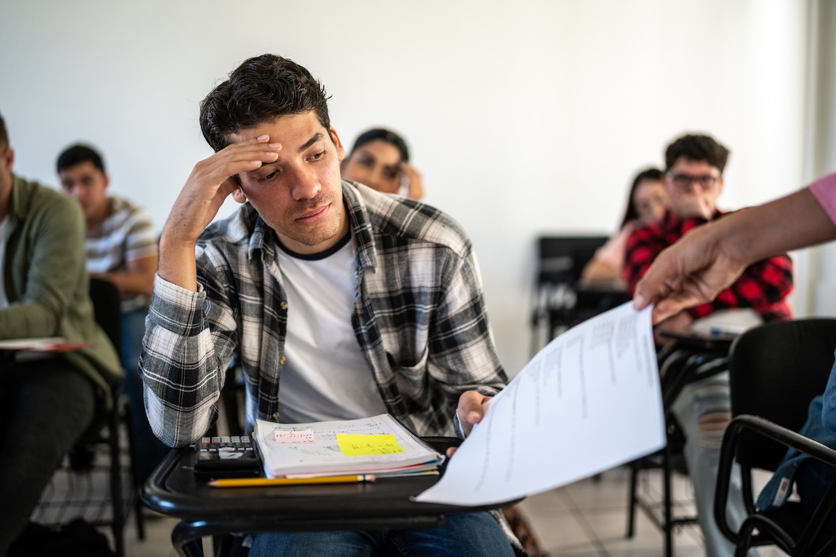 Disappointed male student receiving a test back