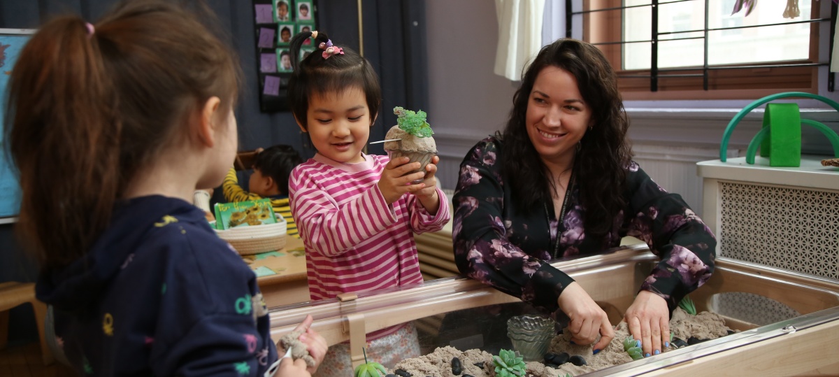 Preschool students play with teacher