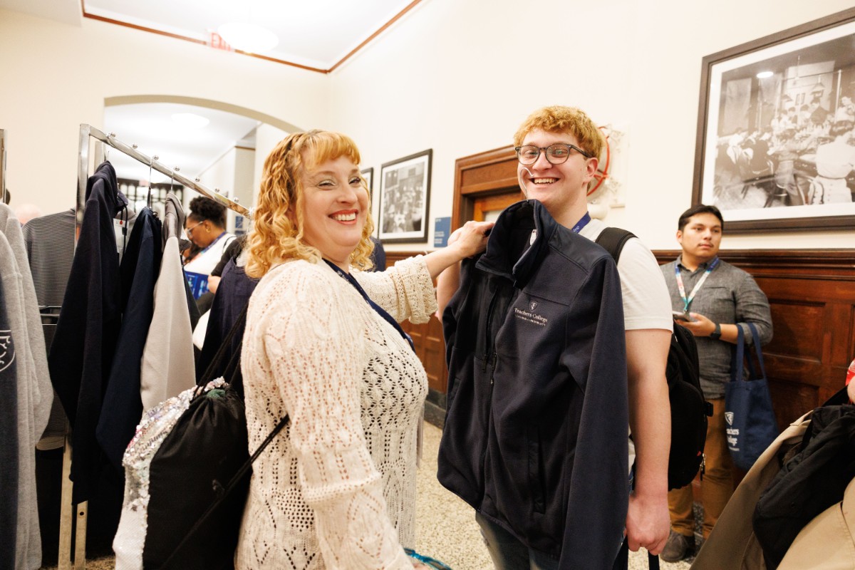 Students trying on various pieces of TC apparel.