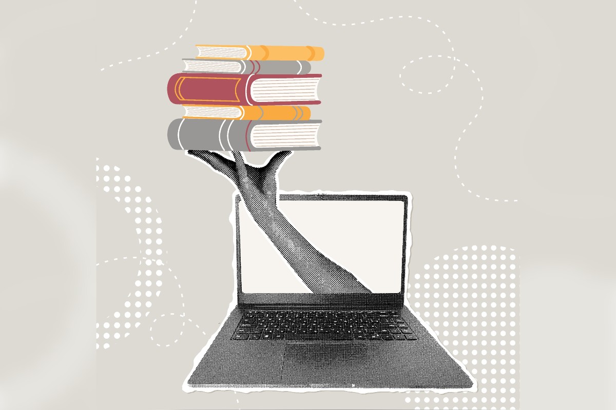 Photo of hand with books and computer.
