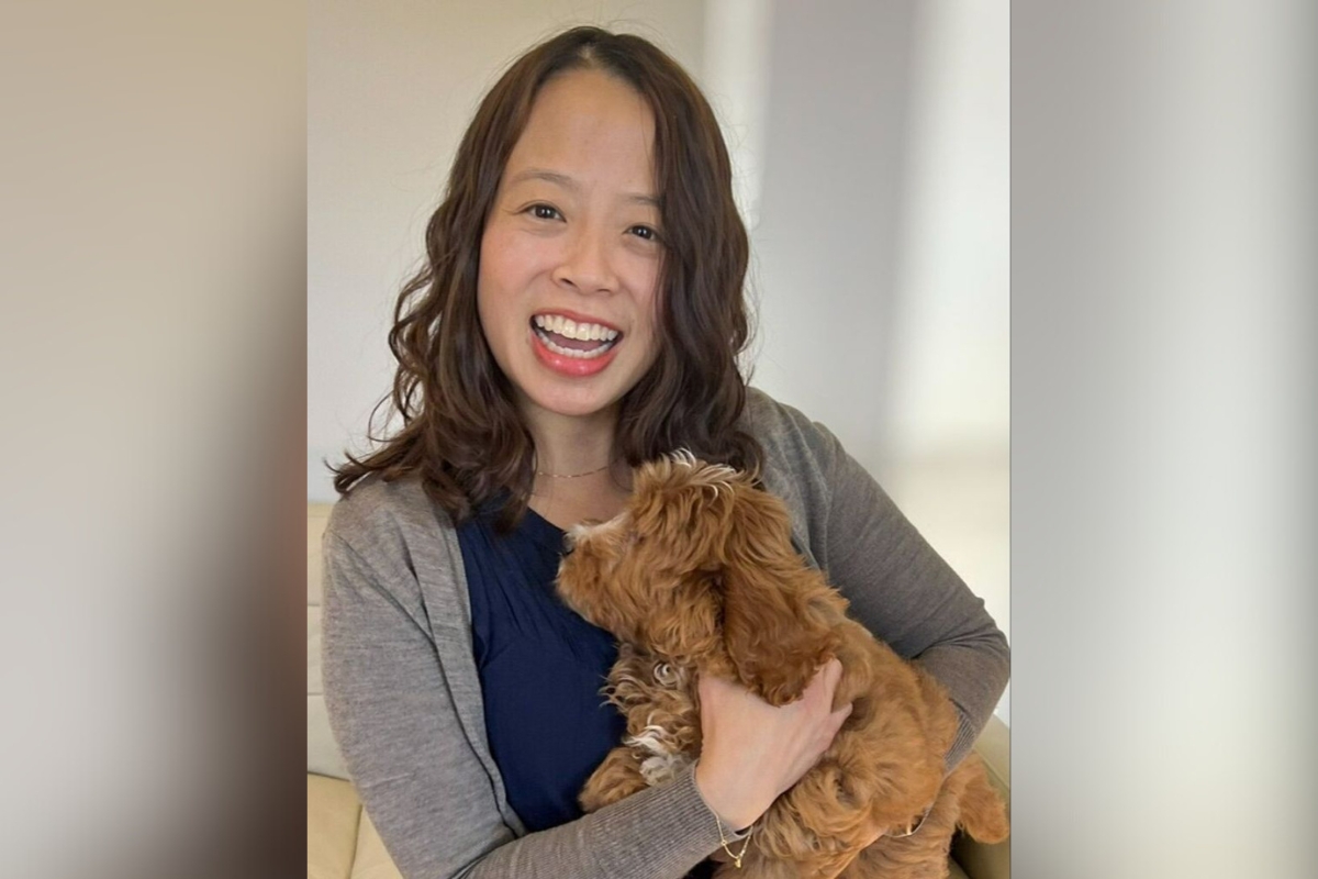 Crystal Chen Lee smiling with a small dog in her arms
