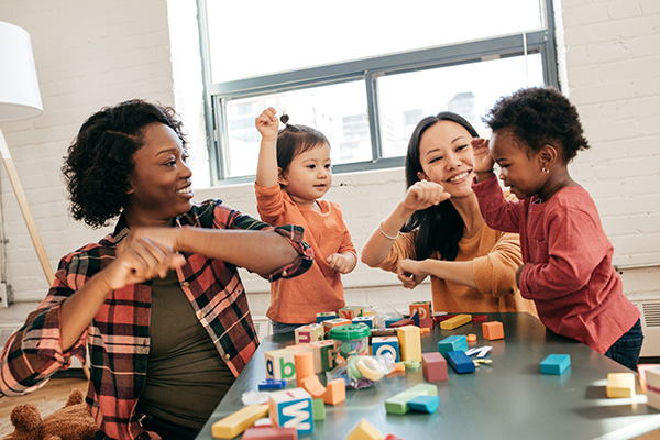 Two young mothers playing with their children