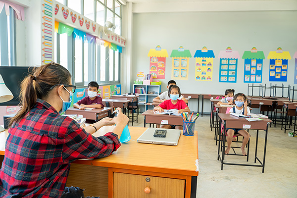 Teacher in a classroom with students wearing masks