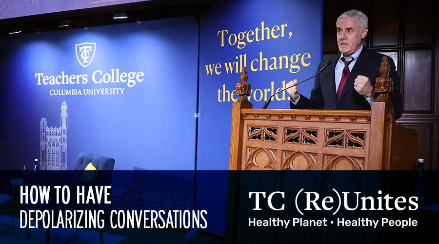 Man standing at a podium and microphone on a stage beside teachers college signage