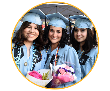 three people wearing graduation cap and cown holding flowers and smiling