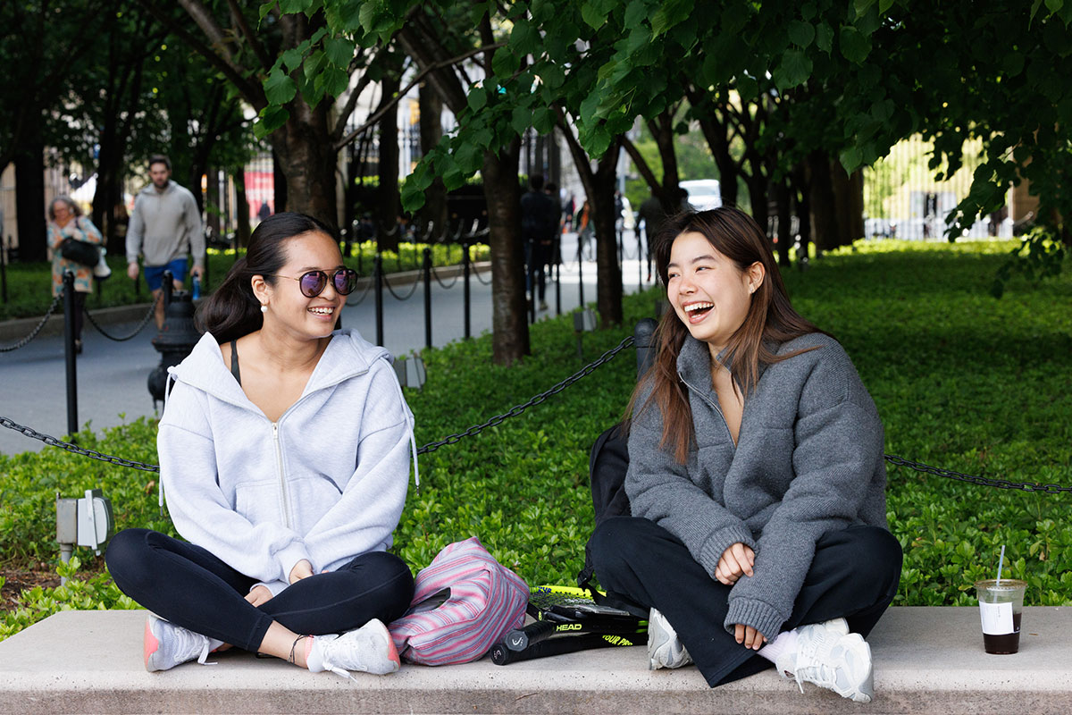 Students laughing and sitting on campus